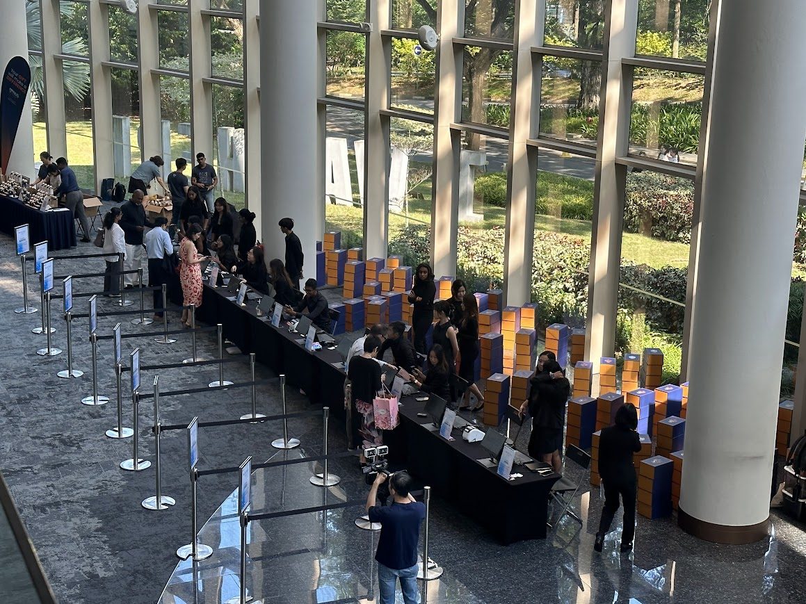 Wide overview of onsite event registration counters, queue lanes and attendee support team